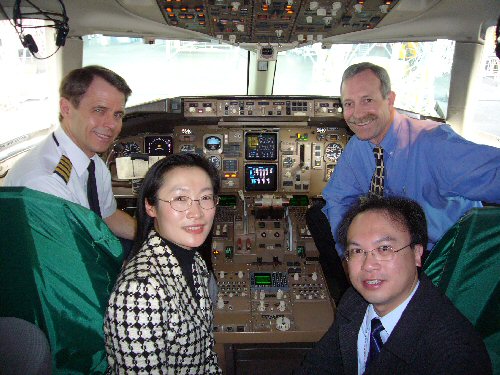 Observatory's Senior Scientific Officers Sandy Song (front left) and BL Choy (front right), and NWA's Chief Pilot Steve Smith (back left) and Meteorologist Tom Fahey (back right) photographed in the cockpit of an NWA aircraft during the media briefing