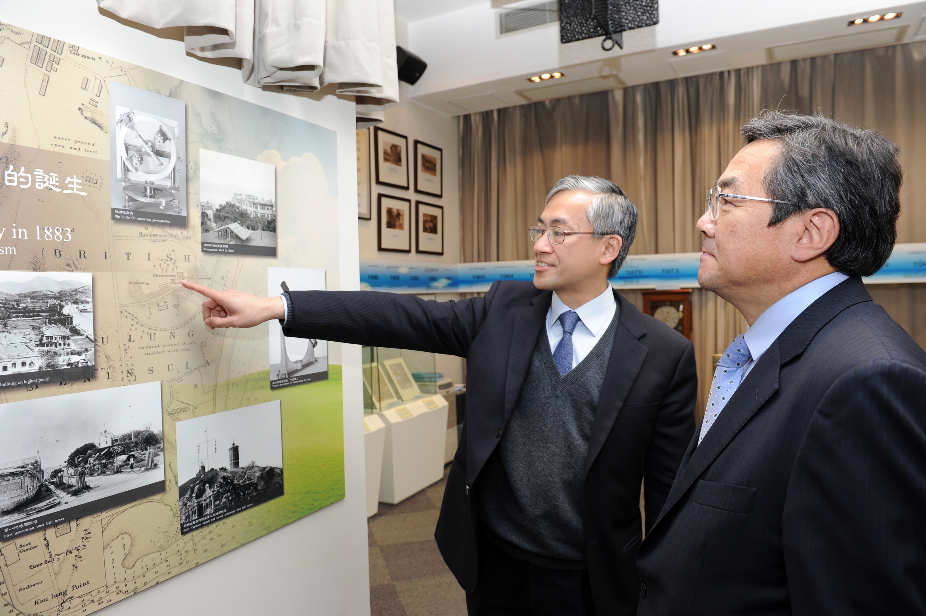 Mr SHUN Chi-ming (left), Director of the Hong Kong Observatory, introducing to Mr Koji SEKIMIZU the history of the Hong Kong Observatory and the meteorological services provided to the maritime community in the past 130 years.