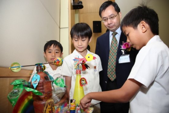Figure 3. Director of the Hong Kong Observatory Dr Lee Boon-ying showing much interest in a merit-winning design of the junior category. 