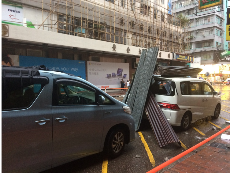 Fallen galvanized iron sheets damaged two private cars in Sham Shui Po. (Photo courtesy of Tam Hiu Fai)