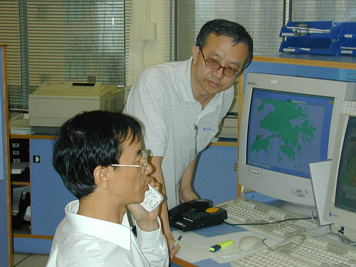 Mr. LUI Yau-lok (standing) in action at the Central Forecasting Office