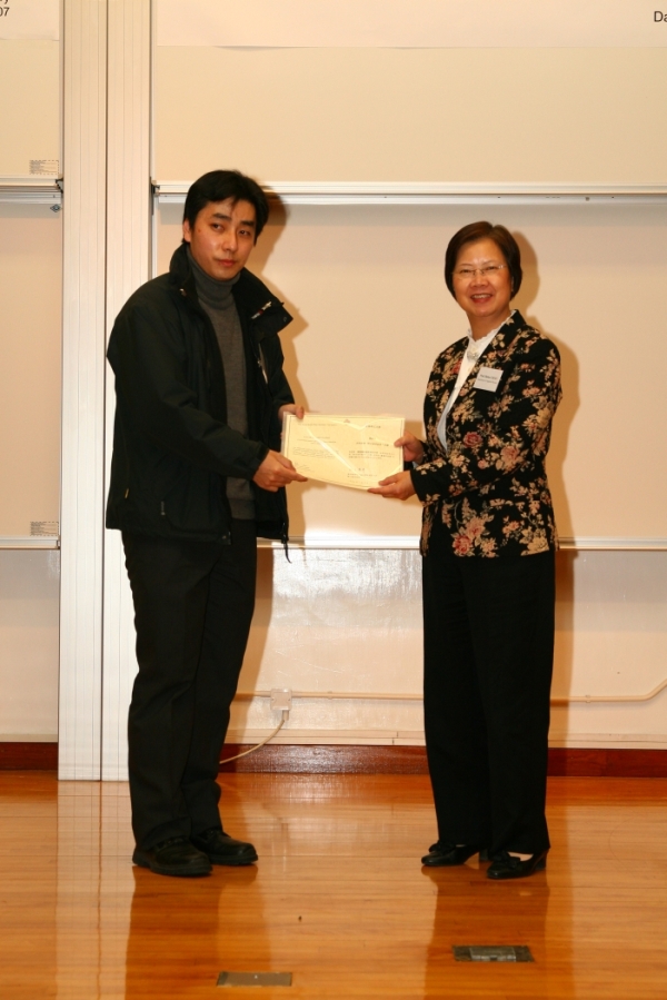 Professor Chan Wong Lai-wa presenting a letter of appreciation to Mr. Liu Man-li, teacher at Shun Tak Fraternal Association Yung Yau College and co-ordinator of the Joint School Meteorological Association.