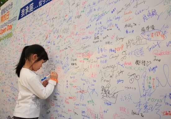 Heavy responsibility at a tender age  - a small girl signing to pledge fighting against global warming