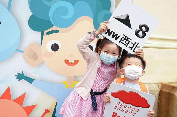 Kids enjoying having a photo taken with weather warning props