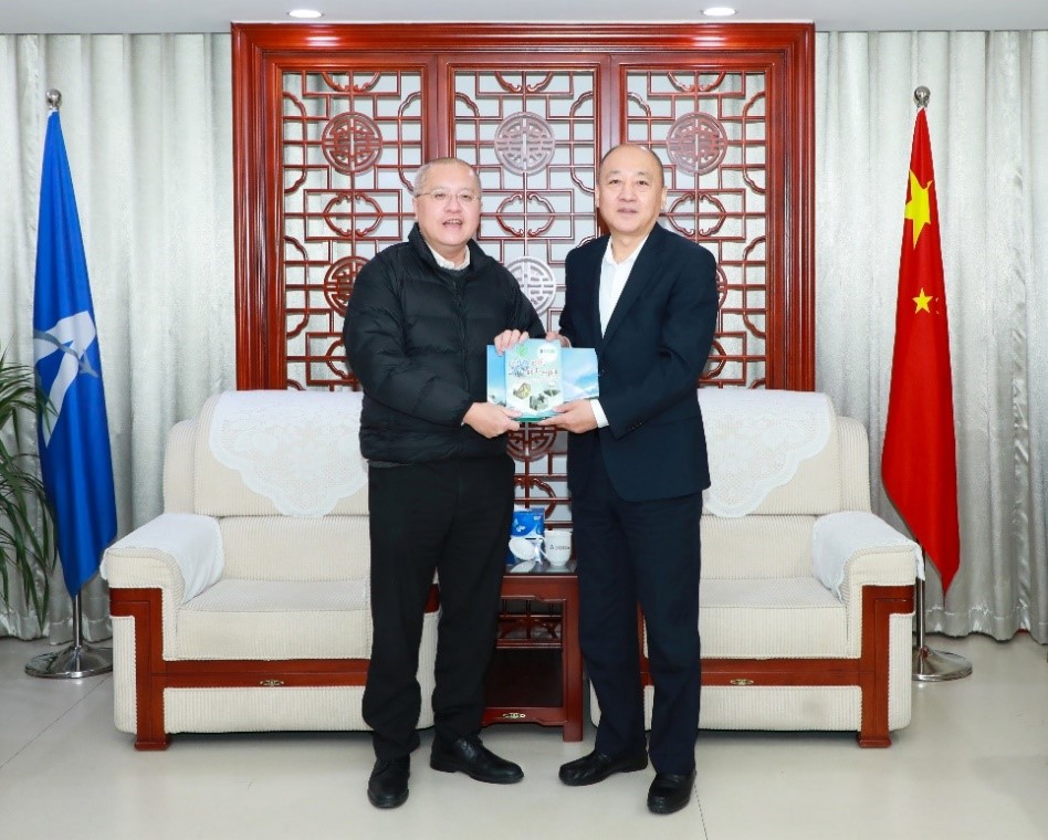 台長陳栢緯（左）向空管局黨委書記、副局長文學正（右）致送天文台為慶祝成立 140 周年推出的紀念文集《聽風．觀雨．說故事》