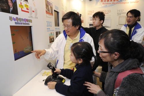 「天文台之友」义工向小朋友示范「风切变飞行」电脑游戏。