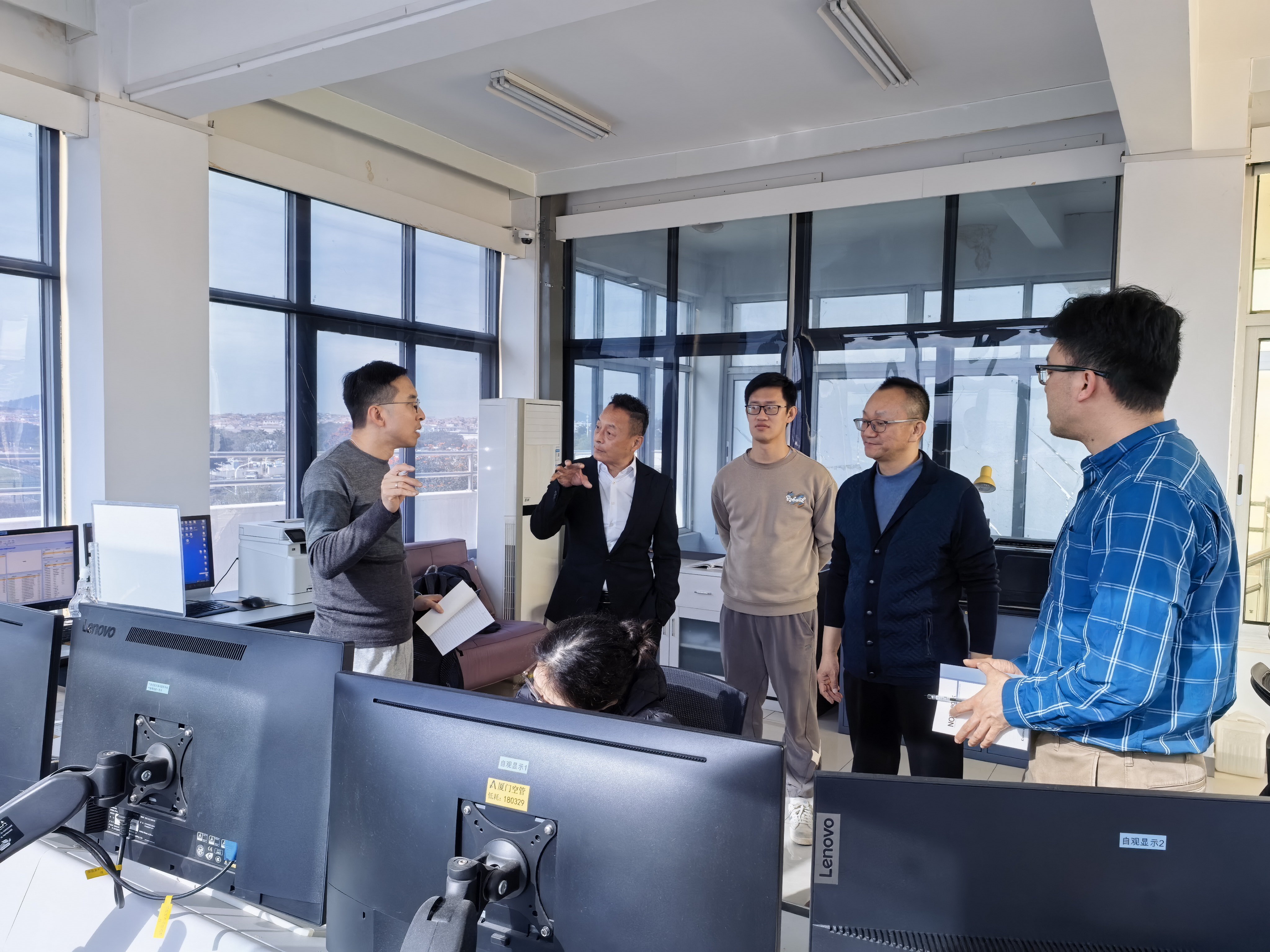 高級科學助理鄭相德先生（左）與天氣觀測員進行交流