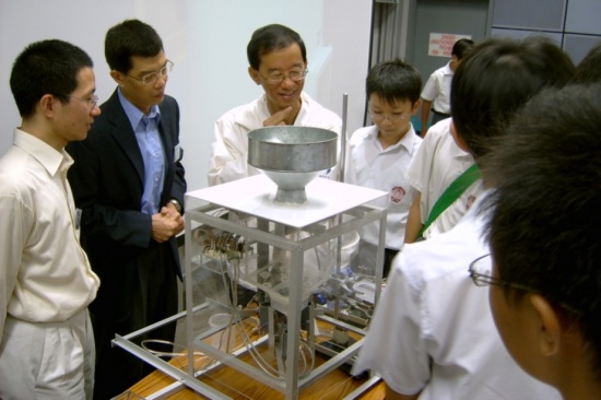 图三: 香港天文台台长林超英先生(左三)与评判香港大学计算机科学系叶志立博士(左一)及电机电子工程系洪仰三博士(左二)以及参赛学生正欣赏高级组冠军的雨量计。